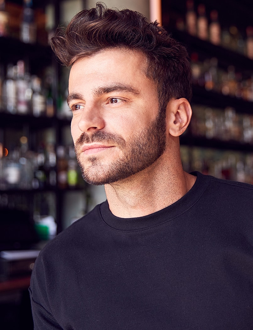 Man with stylish hair in a bar setting.