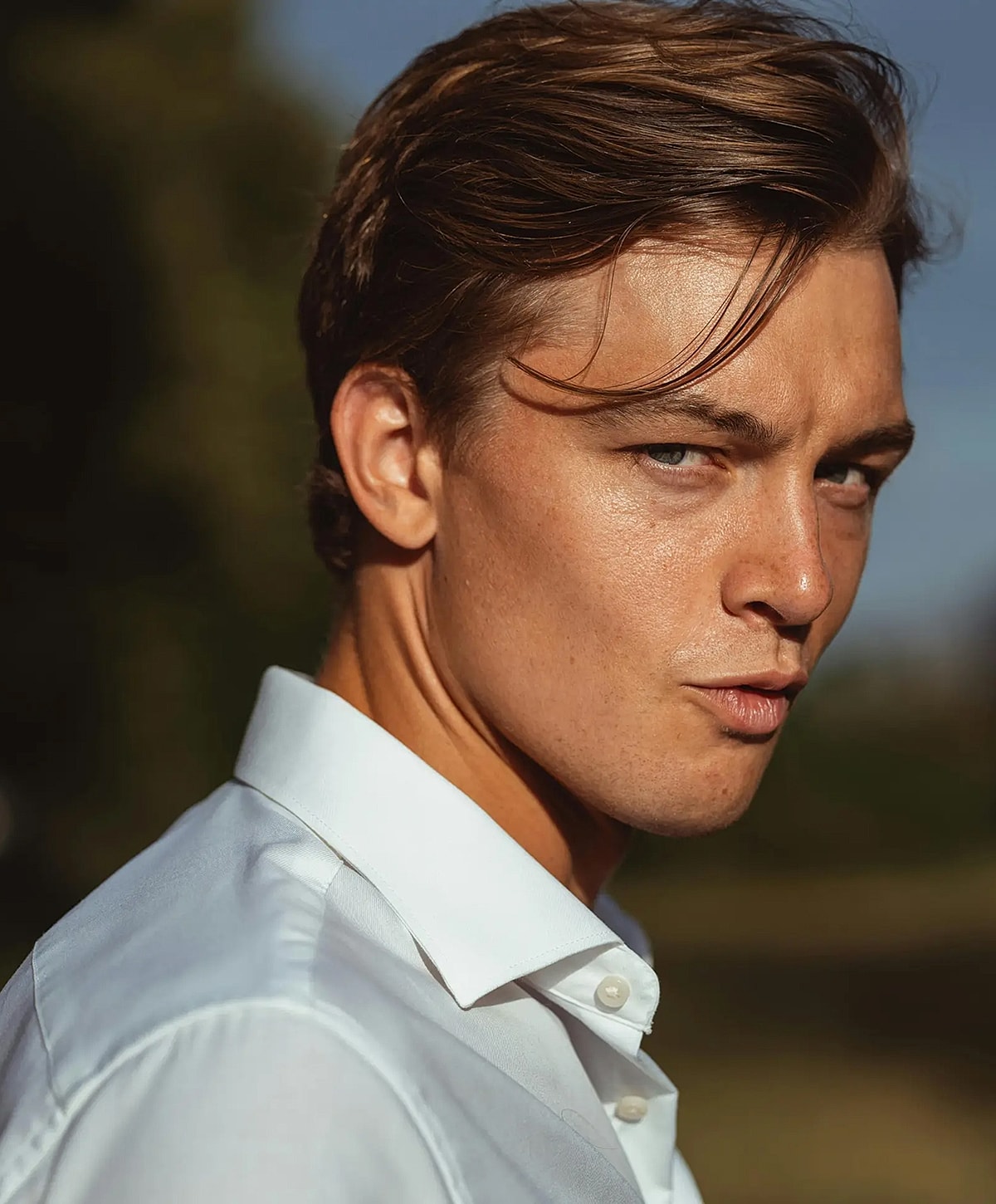 Man with tousled hair in white shirt.