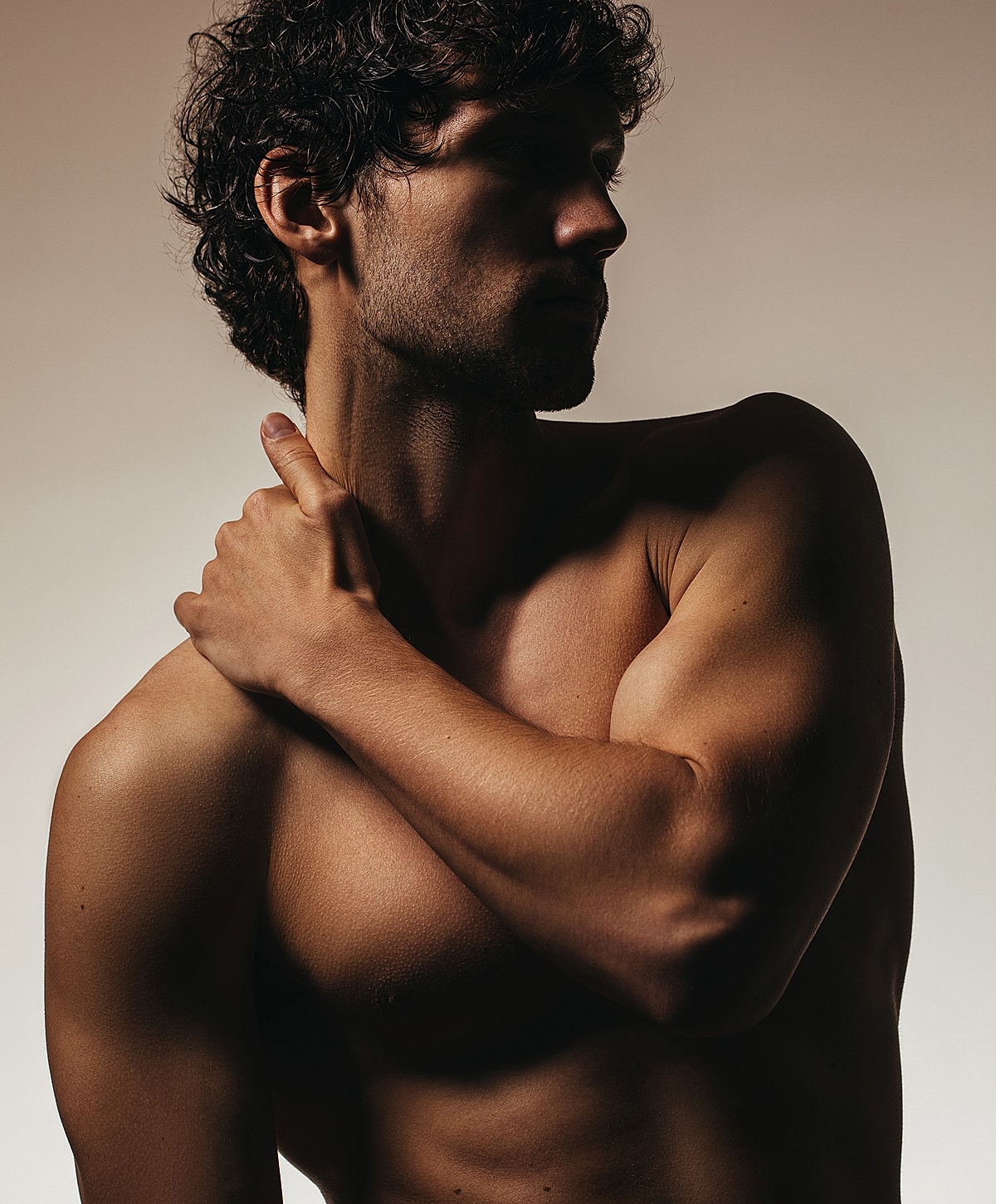 Male model posing in dramatic lighting.