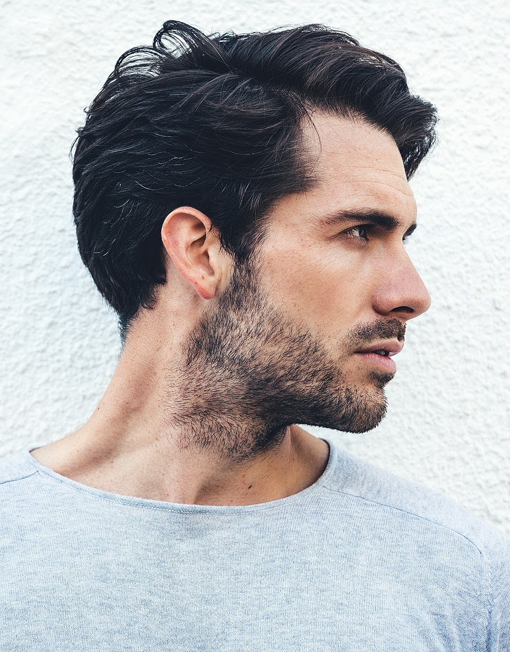 Man with stylish haircut against white background.