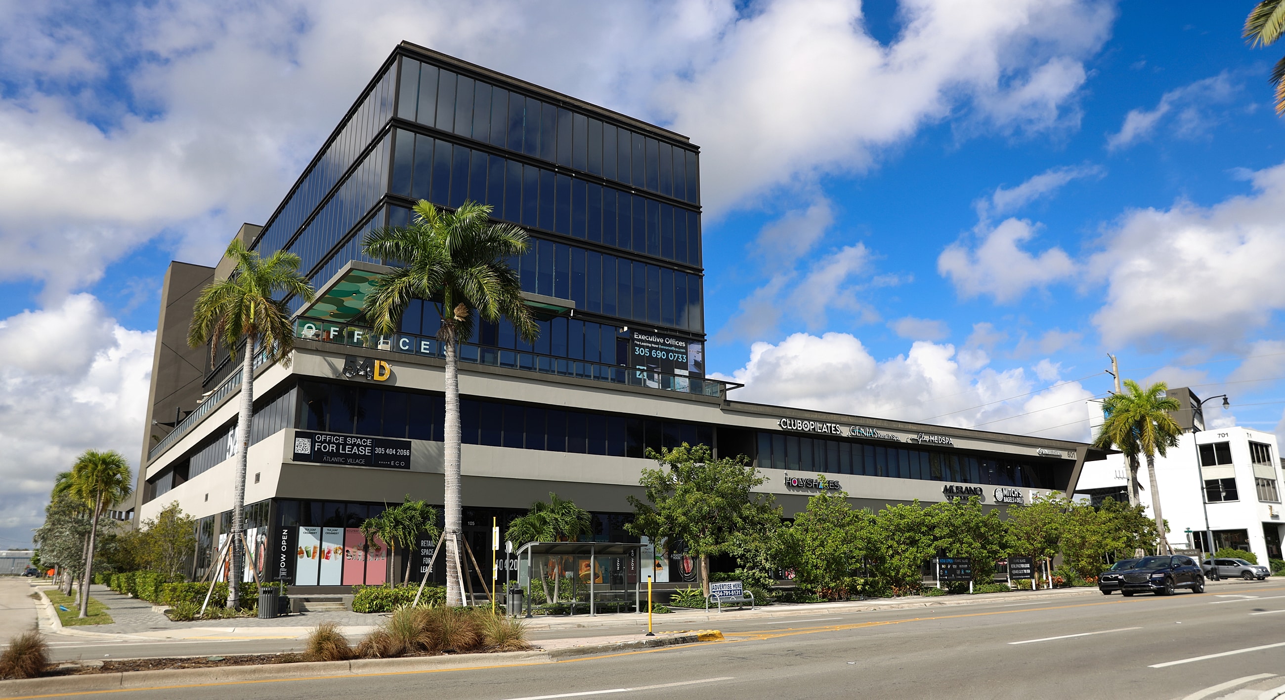 Modern office building with palm trees outside.